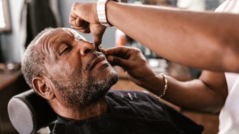 Man in barber chair getting a face shave