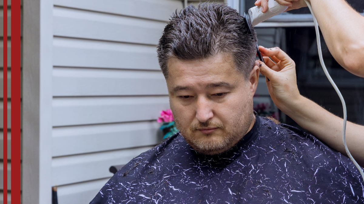 A barber talks through the process with his client of how to get rid of dandruff.
